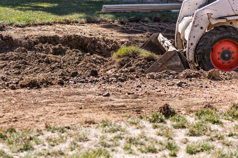 A dirt contractor excavating soil for a construction project.